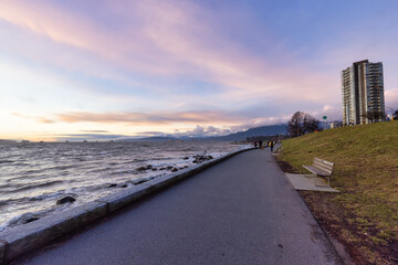 Fototapeta na wymiar Seawall in Downtown Vancouver, British Columbia, Canada. Colorful Winter Sunset. Modern City on the Pacific Ocean West Coast.