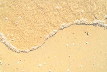 Fototapeta na wymiar Sand with stones and sea water top view background