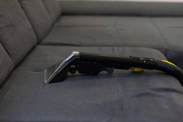 Hand cleaning a sofa with a steam cleaner, Home cleaning concept