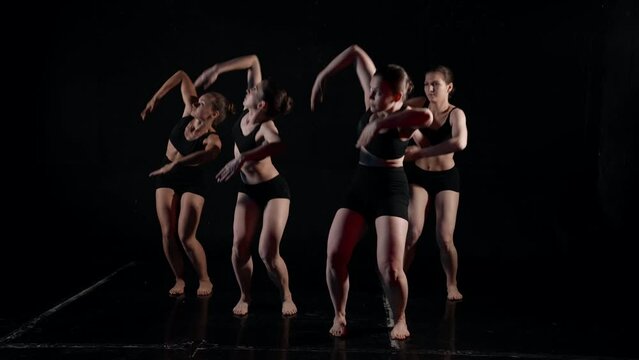 dance team of four sexy ladies, rehearsing in dark hall, contemporary choreography