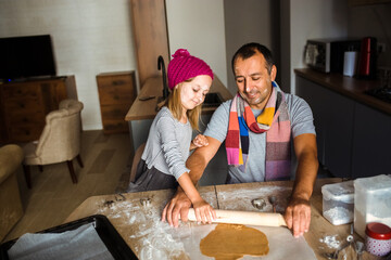 Fototapeta na wymiar Father and daughter cooking cookies at home. Winter concept.