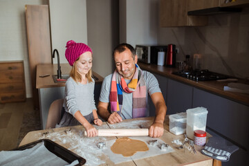Father and daughter cooking cookies at home. Winter concept.