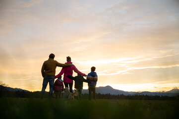 Family of five having fun outside at dusk