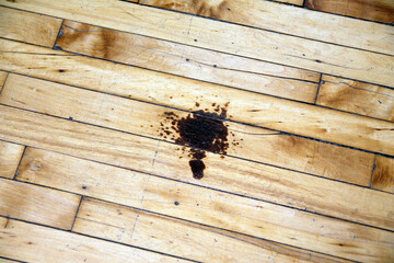 A stain on the brown wooden floor of an industrial space