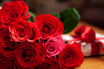 -  roter Rosenstrauß und Geschenk mit roter Schleife -