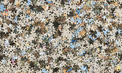 Background from a variety of puzzles on the table. Flat lay. Big pile of puzzles.