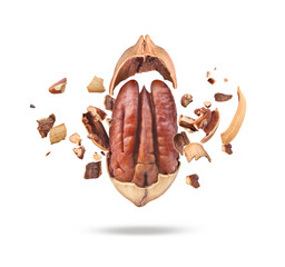Chopped pecan nuts with shells on white plate in the air - obrazy, fototapety, plakaty