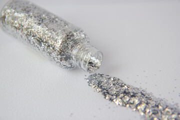 Silver confetti in a transparent bottle on the table