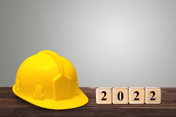 Happy New Year 2022 Construction and Industry. Helmet and a numbered cube on the desk