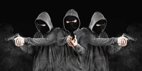 Dangerous hooded group of robbers. Group of anonymous criminals in masks. Smoke and black...