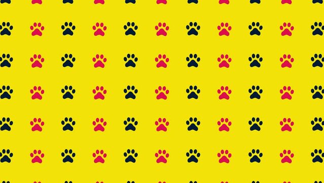 Colorful pattern of black and pink cat paws on yellow background. Seamless pattern with cat paw. Top view. Dog, cat footprint background. 4K video motion