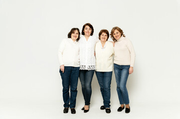 Fototapeta premium grandmother with daughters stands in full growth on a white background. lovely family. group of women of different ages.