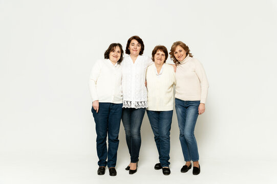 grandmother with daughters stands in full growth on a white background. lovely family. group of women of different ages.