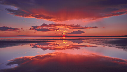 Sun rays and reflection of the sky in the water during a red sunset on the Gulf of Finland of the Baltic Sea.