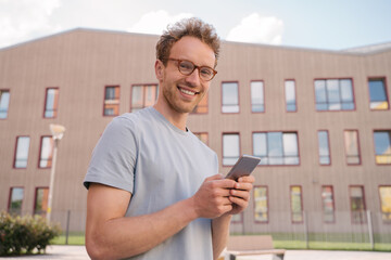 Smiling man using mobile phone shopping online 