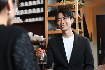 飲食店でワインを飲む男女のカップル（男性メイン）