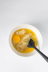 Melted butter, white sugar and an egg in a white bowl