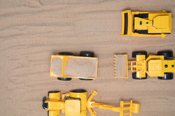 Toy tractors work in the sand. Construction and planning concept. High quality photo