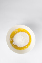 Melted butter and white sugar in a white bowl