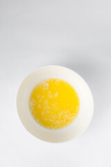 Melted butter in a white bowl, liquid butter