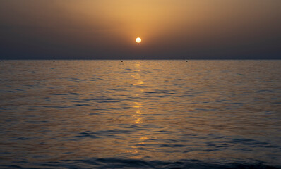 Fototapeta premium Tranquil scene of beautiful sea at sunset. Scenic seascape. Orange and yellow sunset on the sea. Aerial panoramic view of sunset over sea.