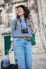 Young woman with suitcase in old city on vacation