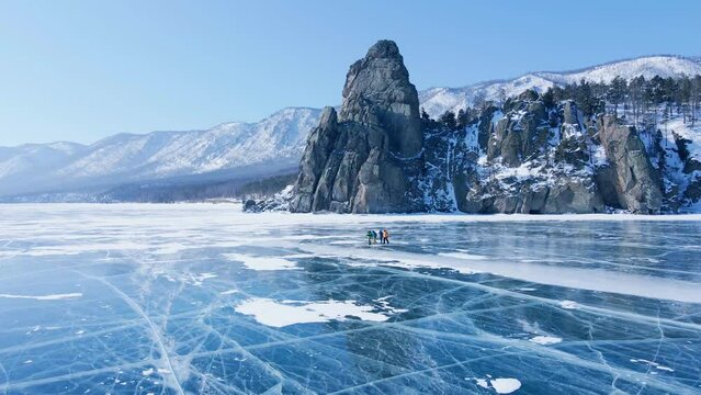 Frozen Lake Baikal, Aerial view. Beautiful winter landscape with clear smooth ice. Famous natural landmark Russia. Blue transparent ice with deep cracks, top view of a frozen lake.
