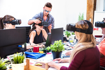 Young people employee workers having fun with vr virtual reality goggles in startup studio - Human...