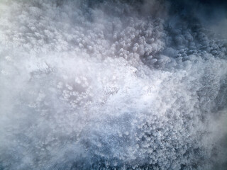 Top view of snowy conifer crowns. Nature pattern. Drone shot.