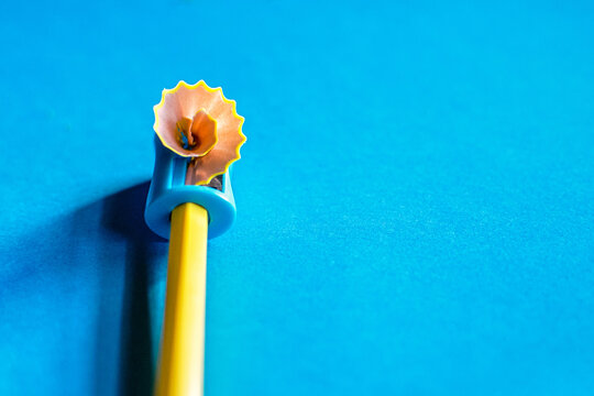Creativity.
Yellow Pencil That Is Sharpened With A Manual Pencil Sharpener. Blue Background