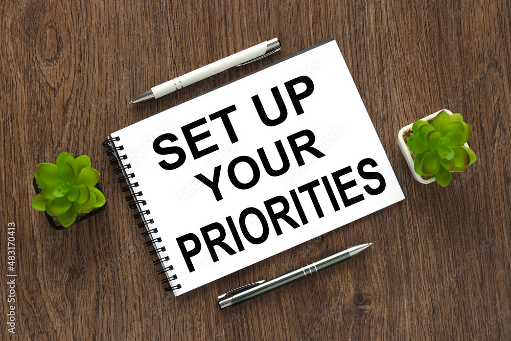 Poster set up your priorities text written on a notebook with pencils