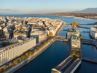 Obraz premium Aerial view of the Rhone river in the heart of Geneva old town and business district before reaching lake Geneva in Switzerland on a sunny fall day
