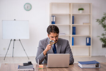 Young male employee sitting in the office