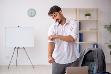 Young male employee sitting in the office
