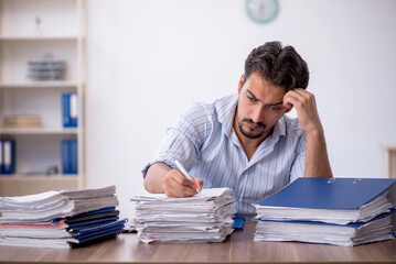Young male employee and too much work in the office