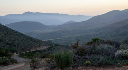 Fototapeta premium A valley of hills fade into the sunrise in Vleiland in the Central Karoo in the Western Cape province of South Africa