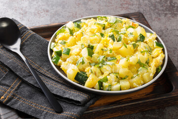 Spanish Scrambled Eggs with Zucchini Onion and Potatoes closeup in the plate on the table. Horizontal