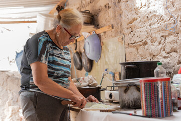 Grandmother chopping onions to cook traditional northern chilean food