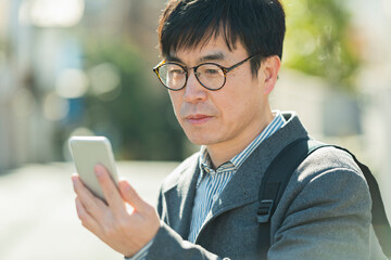散歩中に携帯電話を見る男性