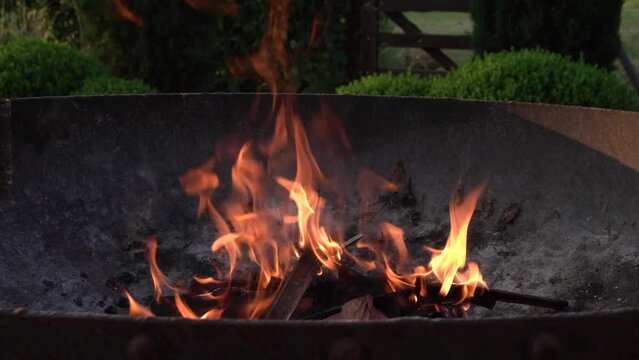 Cooking outdoor. Closeup view of the charcoal and wood fire burning in the metal grill. Beautiful flames texture and motion.