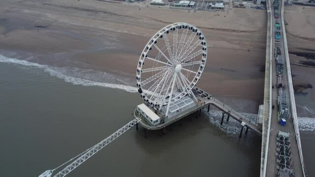 Dutch city Scheveningen pier on the beach with ferris wheel and bungee jump tower, Aerial