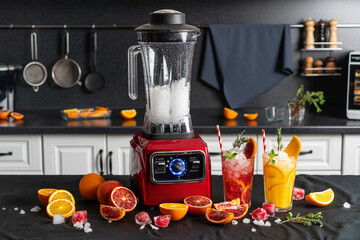 Modern electronic Red blender with crushed ice cubes and cold homemade citrus lemonade in faceted...