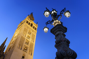 Fototapeta na wymiar The famous Giralda bell tower of Seville cathedral at dusk in Andalusia largest city in Spain. It is a former minaret from the Moor era.