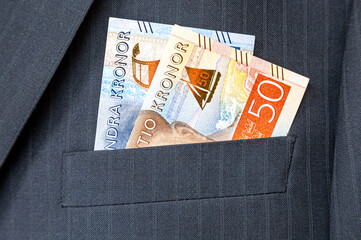 Swedish kronor banknotes sticking out of the businessman suit pocket