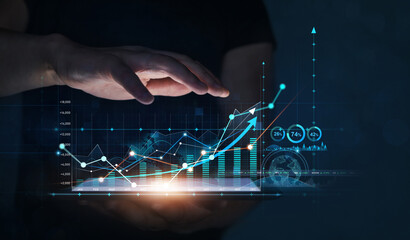 Businessman holding tablet with growing virtual hologram of statistics. Business planning and strategy. Digital marketing and growth graph chart.