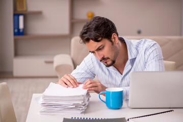 Obraz premium Young businessman employee working from home during pandemic