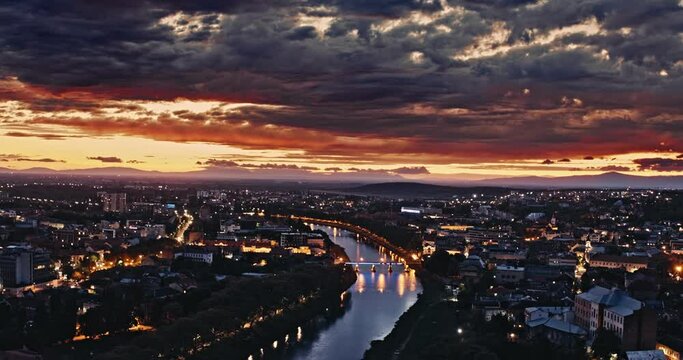 Aerial shot: Incredible sunset over the city. View of the city of Uzhhorod and the river Uzh. 4k