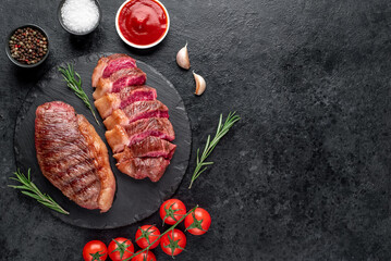 Two grilled picanha steaks with spices on a stone background with copy space for your text