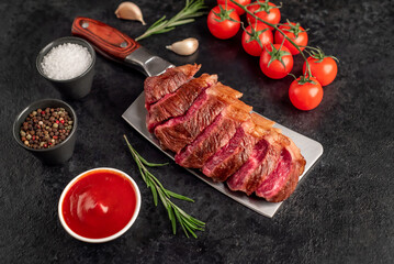 grilled picanha steak with spices on a meat knife on a stone background