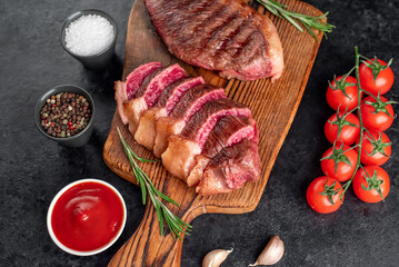 Two grilled picanha steaks with spices on a stone background

